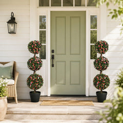 Two artificial rose topiary trees flanking a doorway on a patio