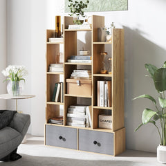 This tall wooden bookcase with grey drawers is displayed in a stylish room with plants and decor