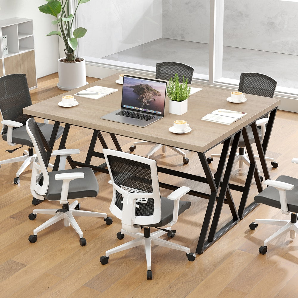 The grey computer desk used as a meeting table in a modern office space