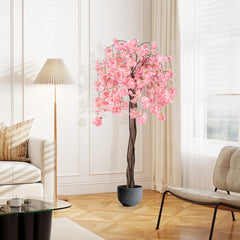 Artificial cherry blossom tree with pink flowers in a grey pot in a living room
