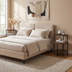 Rustic brown 3-tier round side tables next to a bed in a bedroom