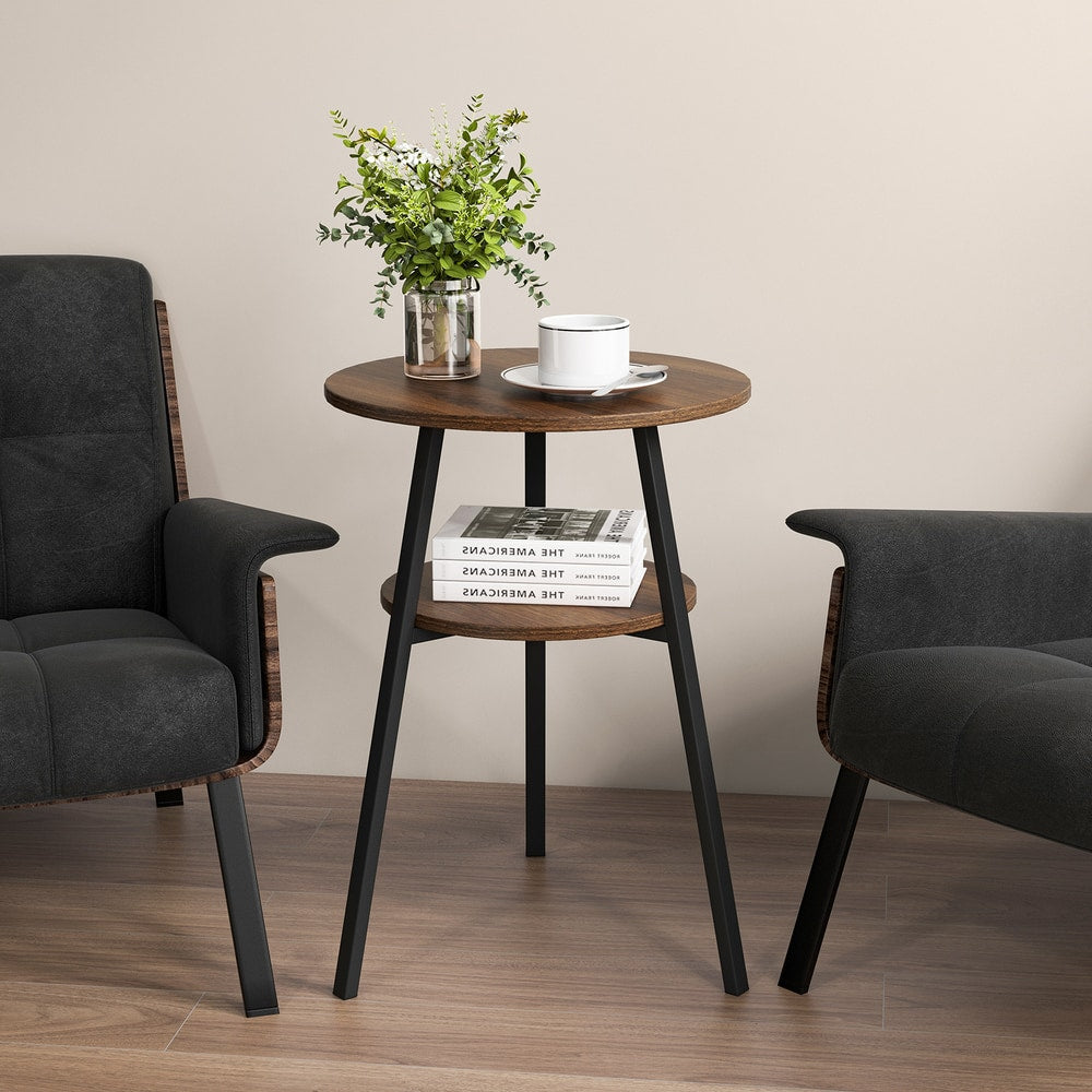 The end table positioned between two dark armchairs with a plant and cup on the tabletop