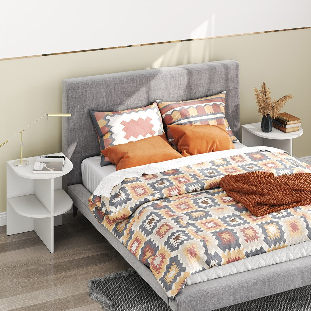 White half round end table next to a bed