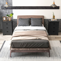 Two black vintage nightstands with three drawers, one on each side of a bed