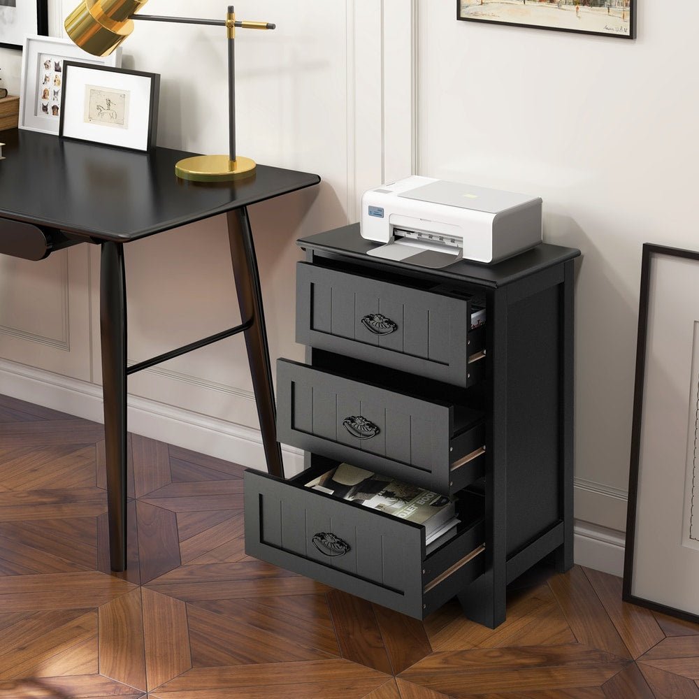 Black vintage nightstand with three drawers open, next to a desk with a printer