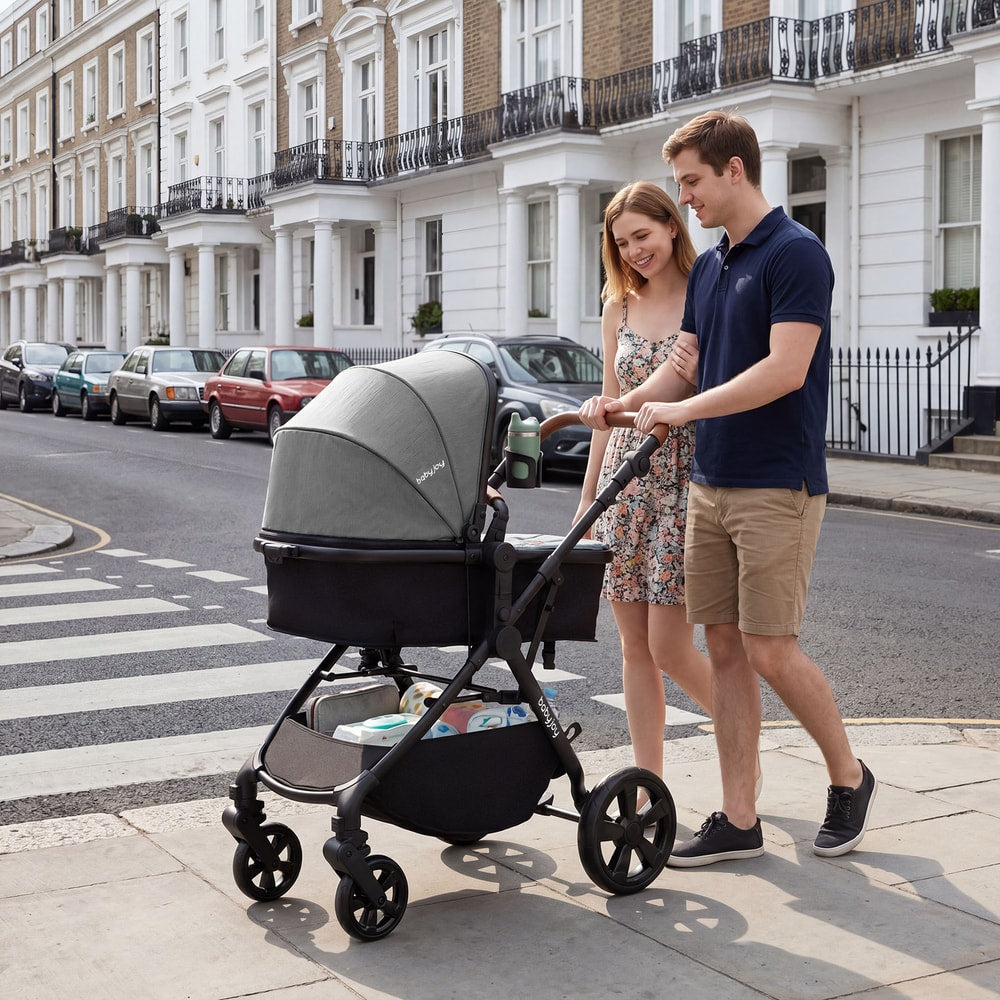 A couple strolls with the convertible baby stroller on a city street