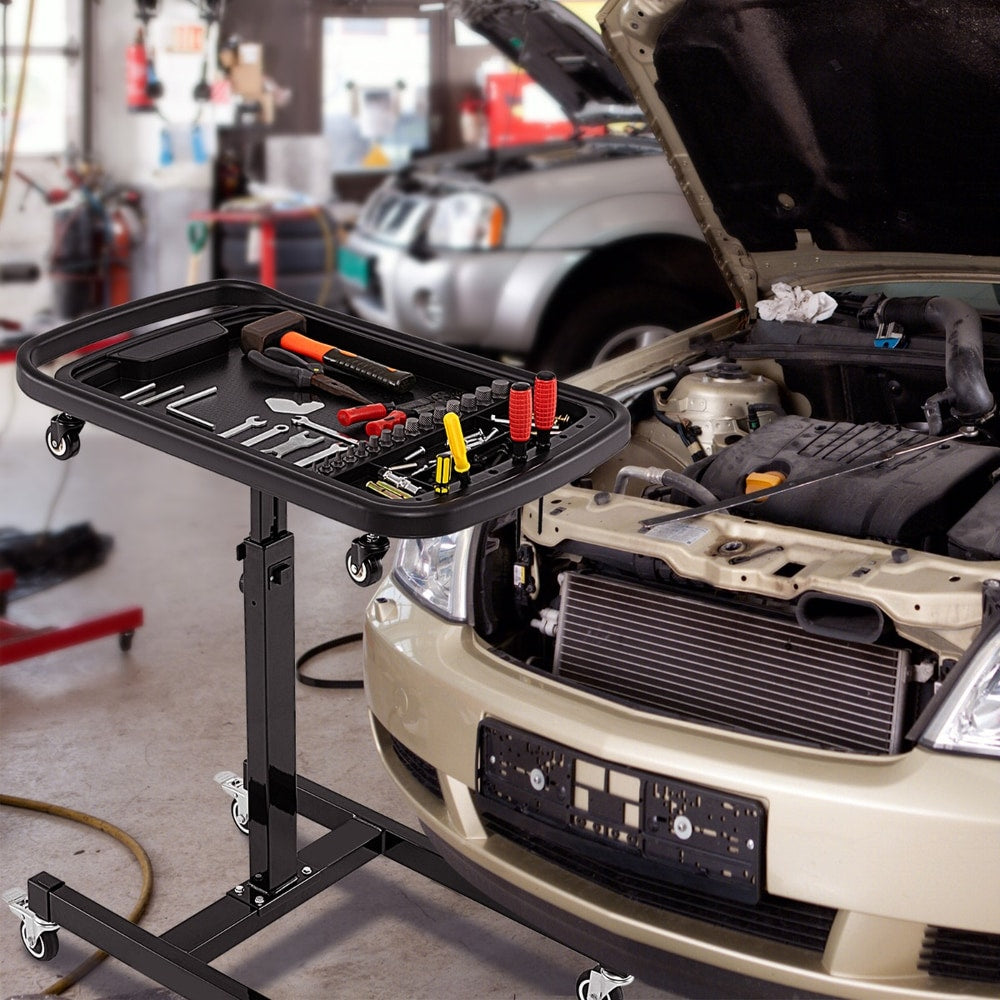 Rolling tool tray with detachable part tray next to a car engine bay in a garage