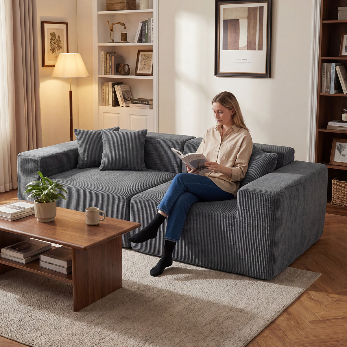 The loveseat with a woman sitting on it reading a book in a cosy home interior