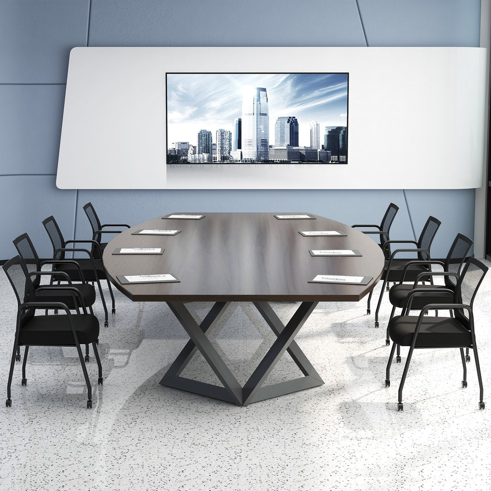 The office chairs set up around a large oval boardroom table with a wall screen