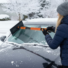 A woman uses the extendable snow shovel to clear snow from a car windscreen