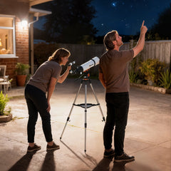 The astronomy telescope being used by a couple in a garden at night to look at the stars