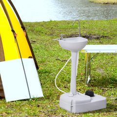 The portable handwash sink set up next to a tent and table outdoors