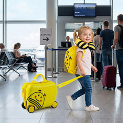 This yellow kids luggage set with a bee design is being pulled by a child