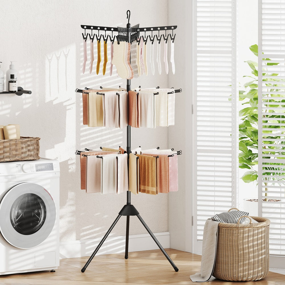 The towel rack with clothes drying in a utility room next to a washing machine