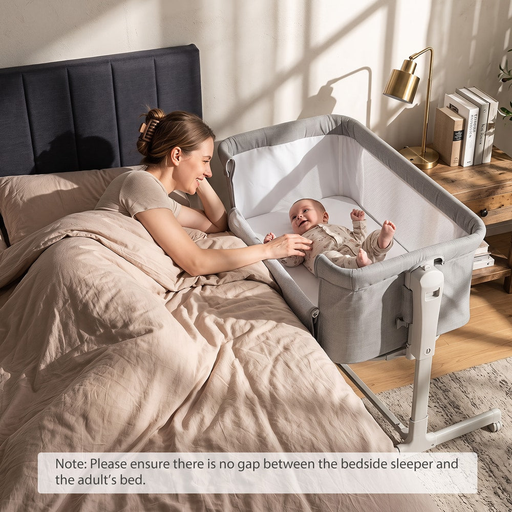 Mother interacting with her baby in the grey bedside sleeper