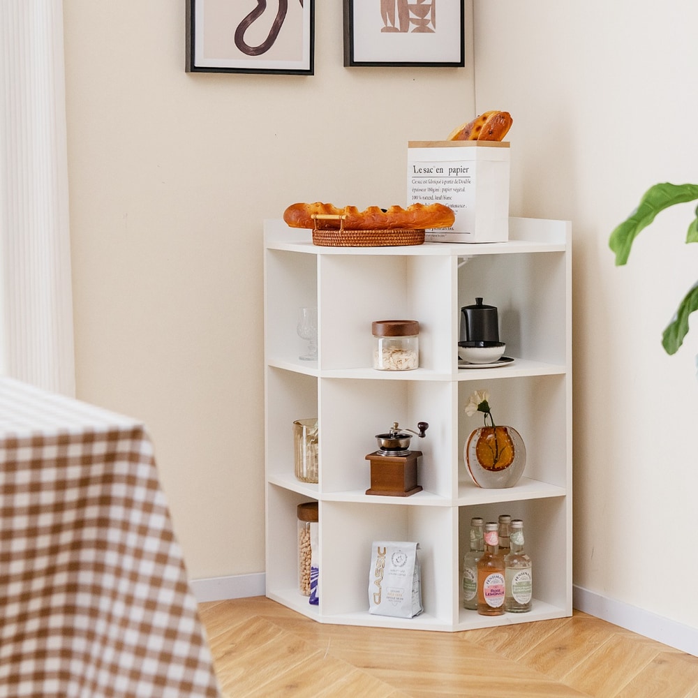The white corner cabinet placed in a room corner with decorative items and food on the shelves