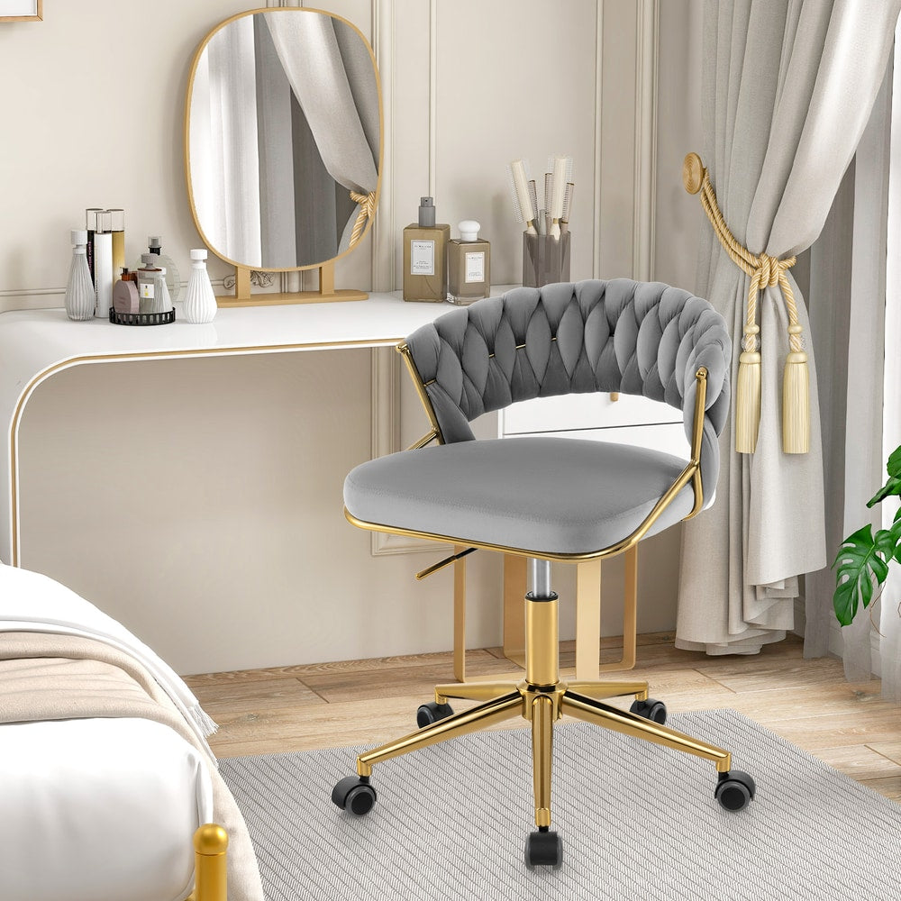 Grey office chair with gold legs next to a bed