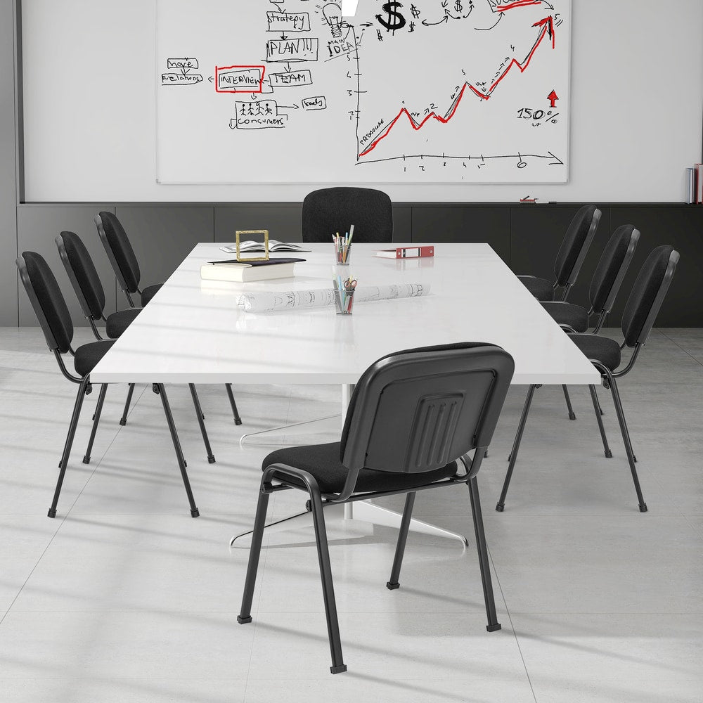 Four black conference chairs around a white meeting table in a modern office