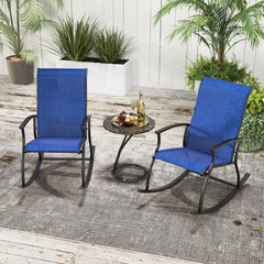 Two navy blue outdoor rocking chairs placed on a rug in a garden setting with a small table between them