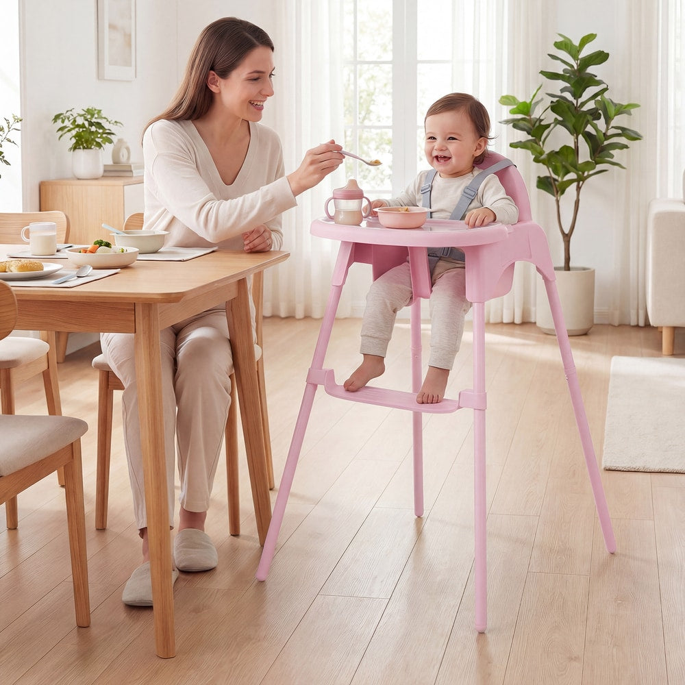 A mother feeding her baby in the pink convertible high chair at a wooden dining table