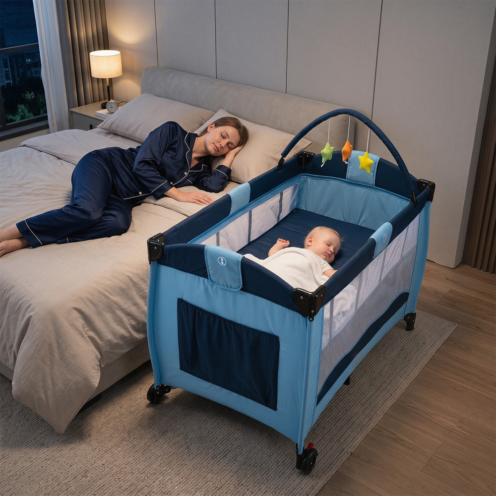The baby playpen with a baby sleeping inside next to a bed where a woman is resting