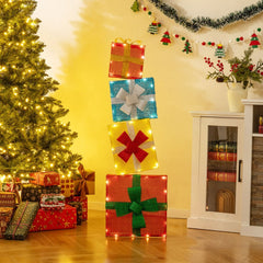 The lit gift boxes standing on a wooden floor beside a Christmas tree