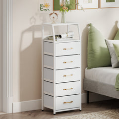 The white chest of drawers positioned in a bedroom beside a bed with green pillows