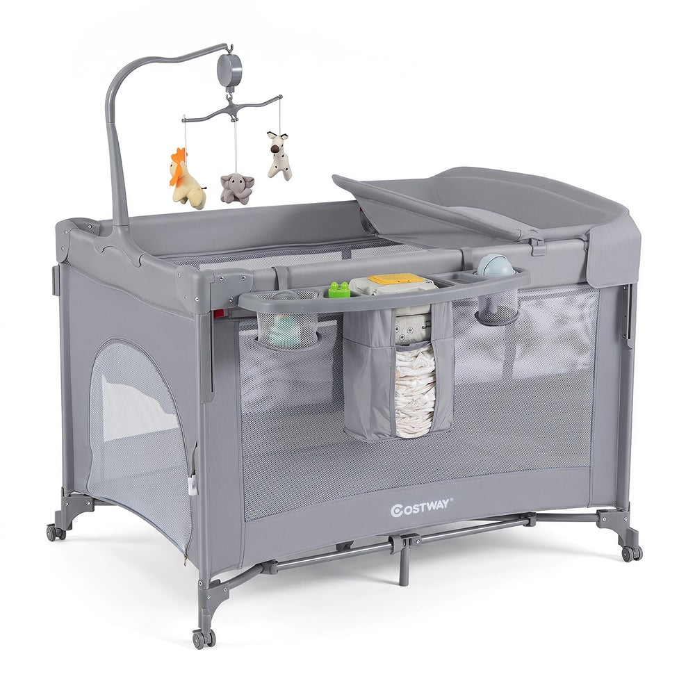The grey infant bedside sleeper with a changing table and hanging toys
