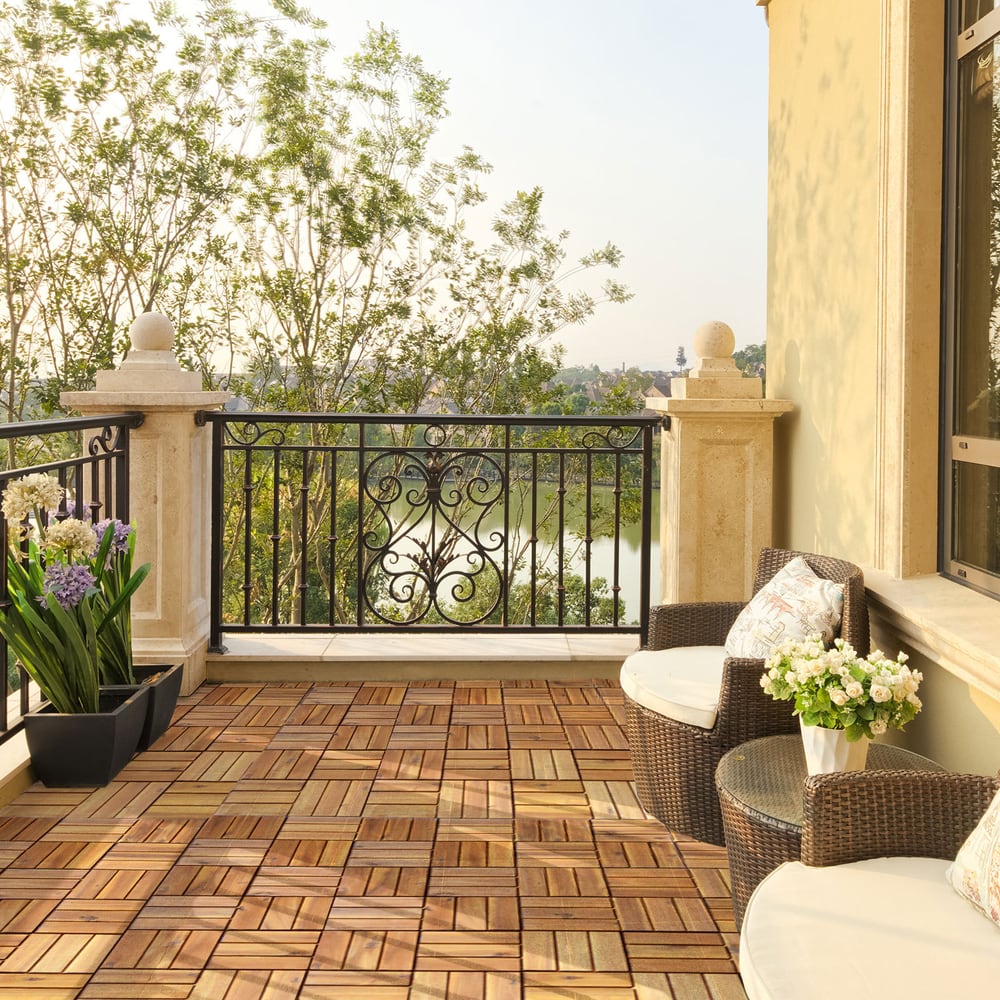 The wooden deck tiles installed on a balcony with outdoor furniture