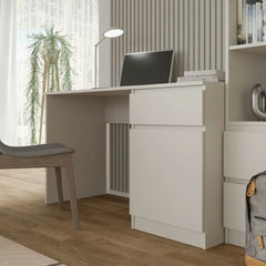 The white desk with a drawer and cupboard unit positioned in a room