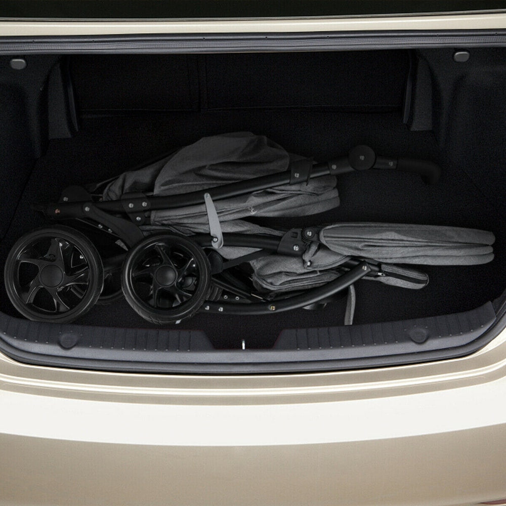 Folded grey double pushchair stored in the boot of a car