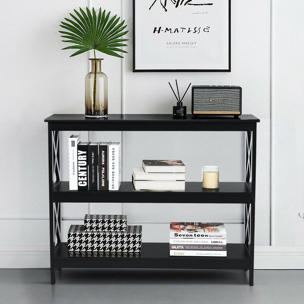 Black three-tier console table with books, a candle and a speaker, styled in a room