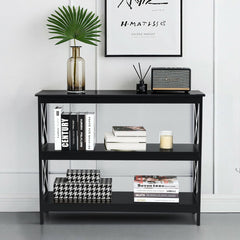 Black three-tier console table with books, a candle and a speaker, styled in a room