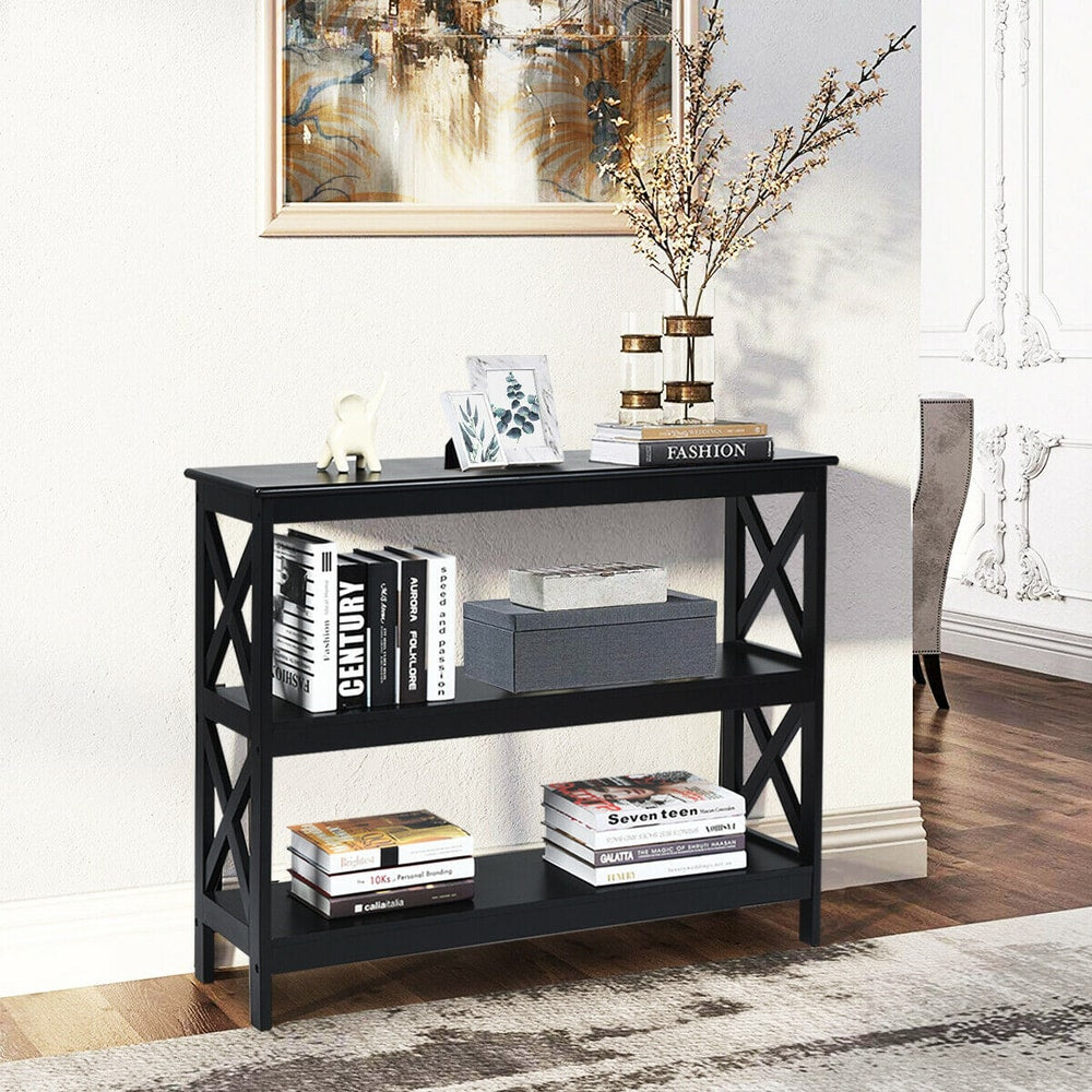 Black three-tier console table with books and decorative items on shelves, in a hallway setting