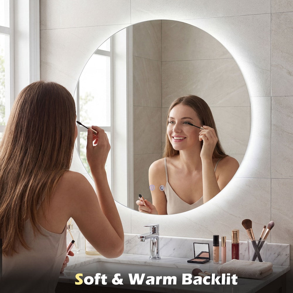 A woman applies mascara using the reflection of the backlit round mirror
