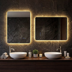 Two lighted mirrors above sinks in a dark tiled bathroom with wooden vanity