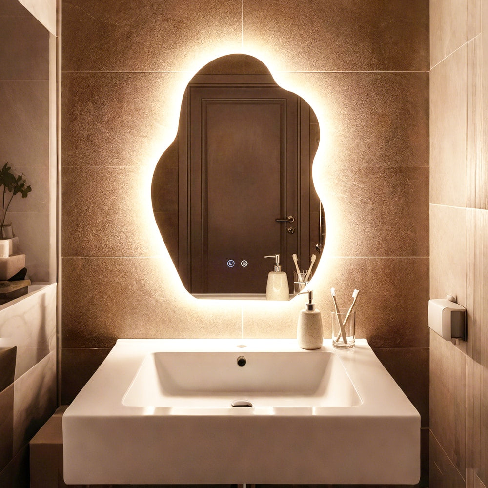 The irregular LED bathroom mirror with 3 light colors, lit up above a sink