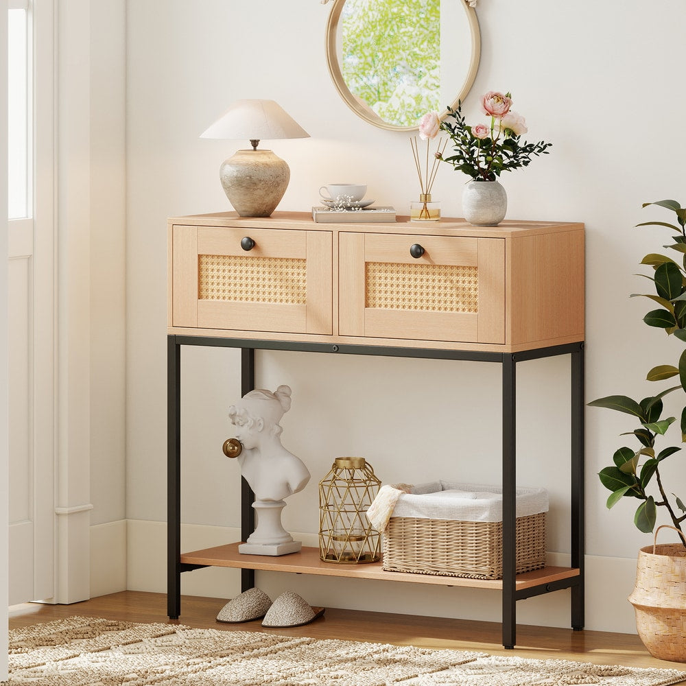 The console table styled in a hallway with a lamp, flowers, and a decorative bust