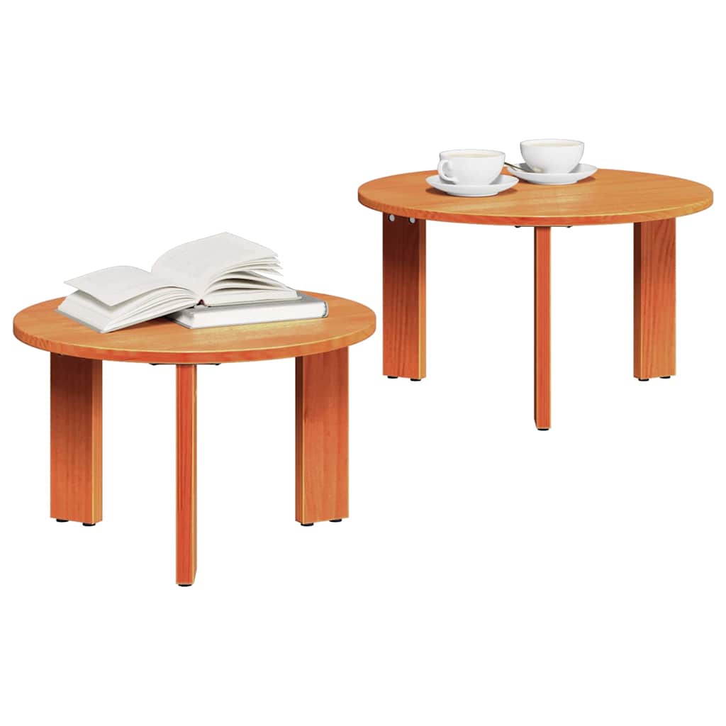Two wooden coffee tables, one with a stack of books and the other with two cups of tea