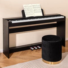 The digital piano set up in a living room with a music book and a velvet stool