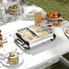 The electric buffet server set up on a picnic table with food in the trays
