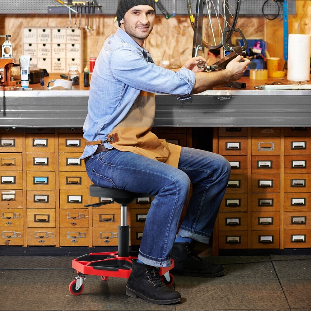 Man working on a bicycle using the creeper seat with tool tray