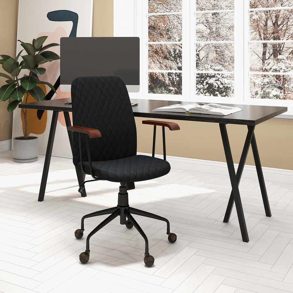 The office chair positioned at a dark desk in a bright room with a large window and plant