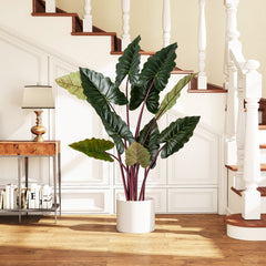 Artificial taro tree in a white pot in a hallway next to a table