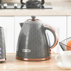 The grey honeycomb kettle sitting on a wooden kitchen worktop next to a white teacup