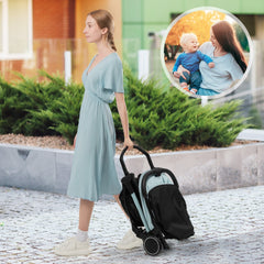 The baby stroller folded and being carried by a woman walking along a stone path