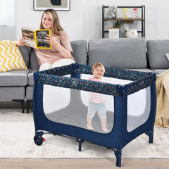 Child standing inside the blue baby playpen in a living room