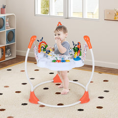 A baby is happily bouncing in the orange baby jumper and bouncer on a patterned rug