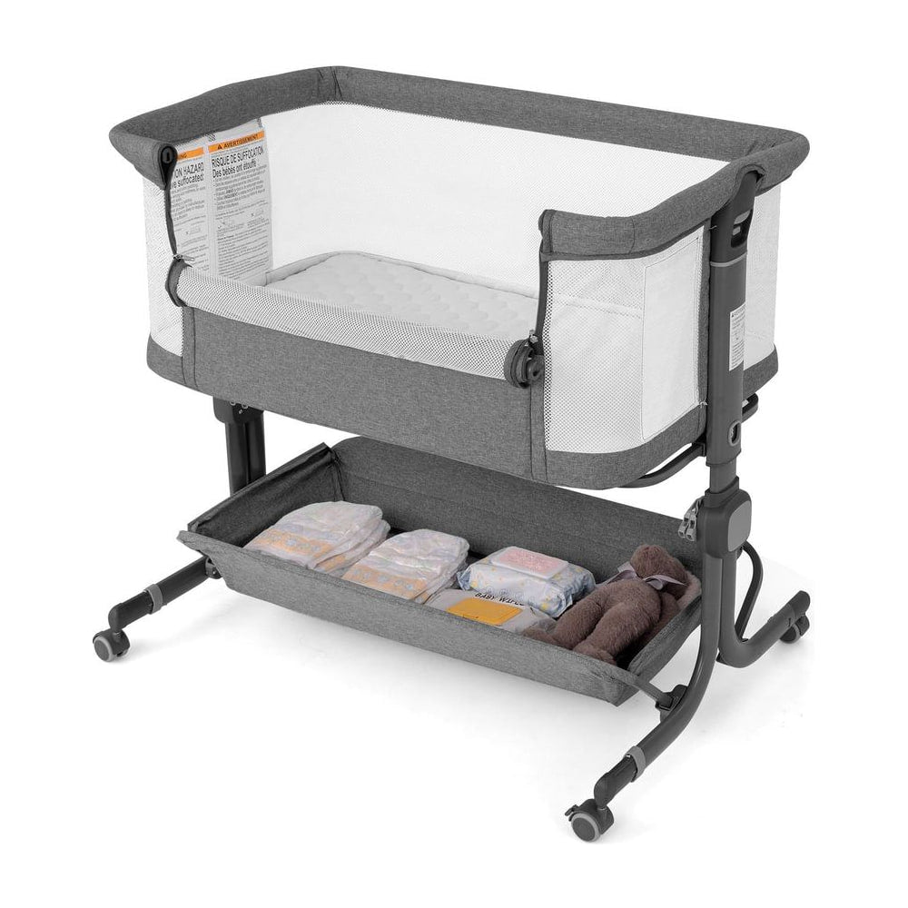 Baby Bassinet Bedside Sleeper in grey with a storage shelf underneath holding nappies and a teddy bear