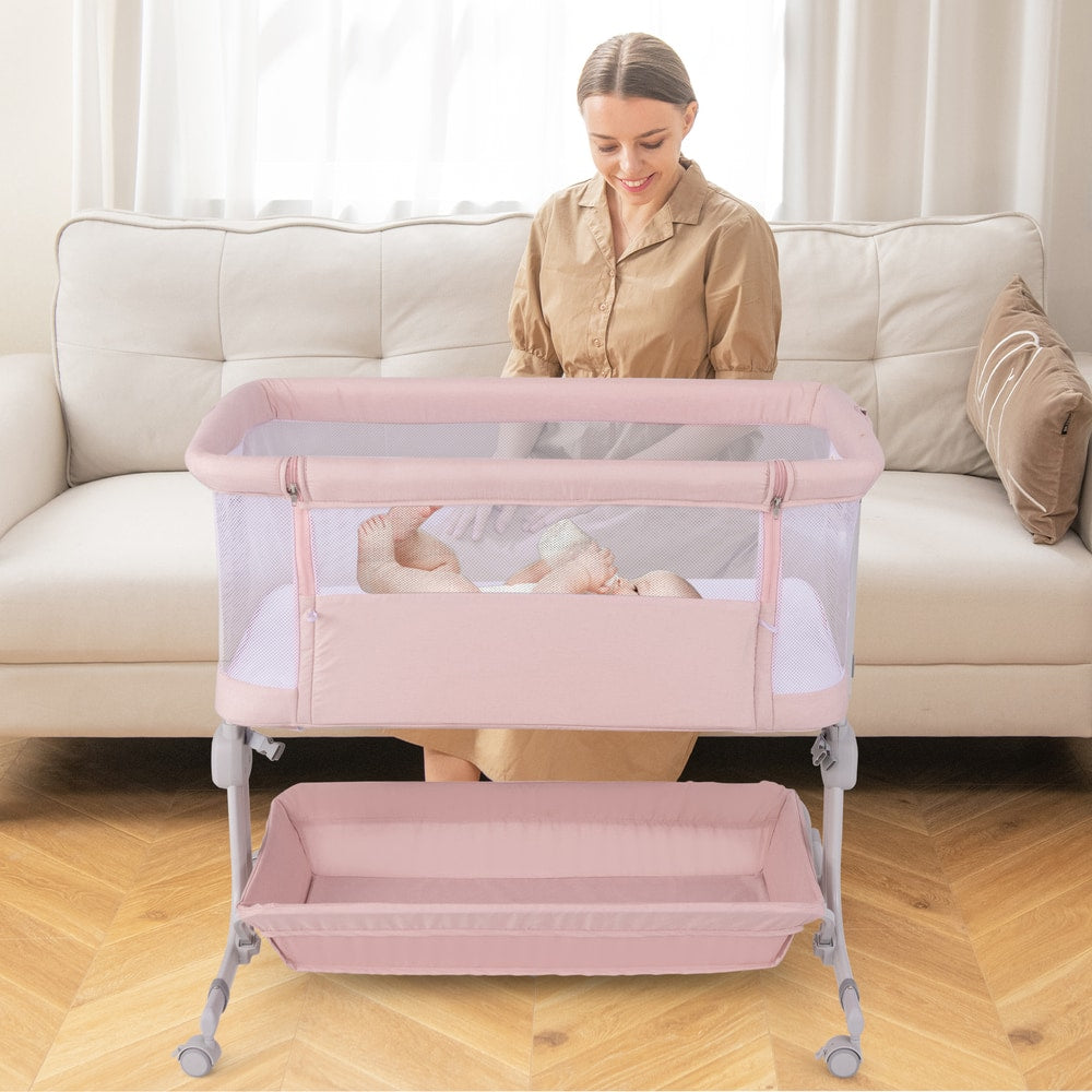 The bassinet is positioned in front of a sofa with a baby sleeping inside and a woman behind